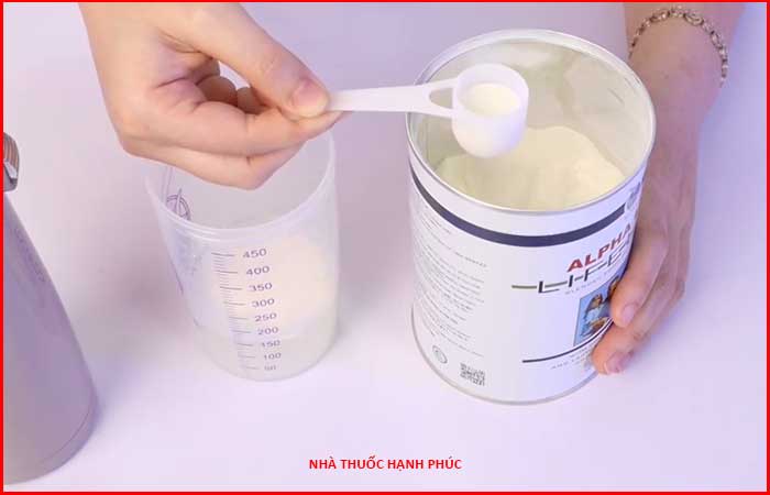 Múc lượng bột sữa non Alpha Lipid cần dùng ra bình lắc